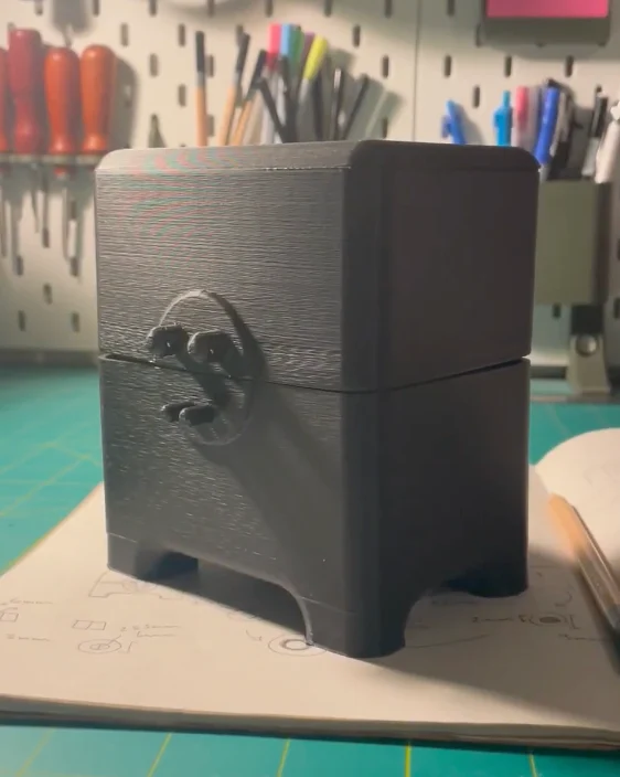 The first version of the FDM printed box in black, with a round latch