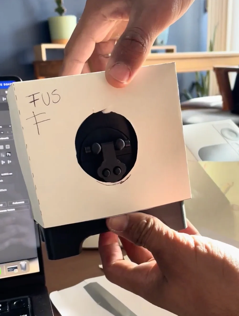 A paper prototype with a round cut-out revealing the latch