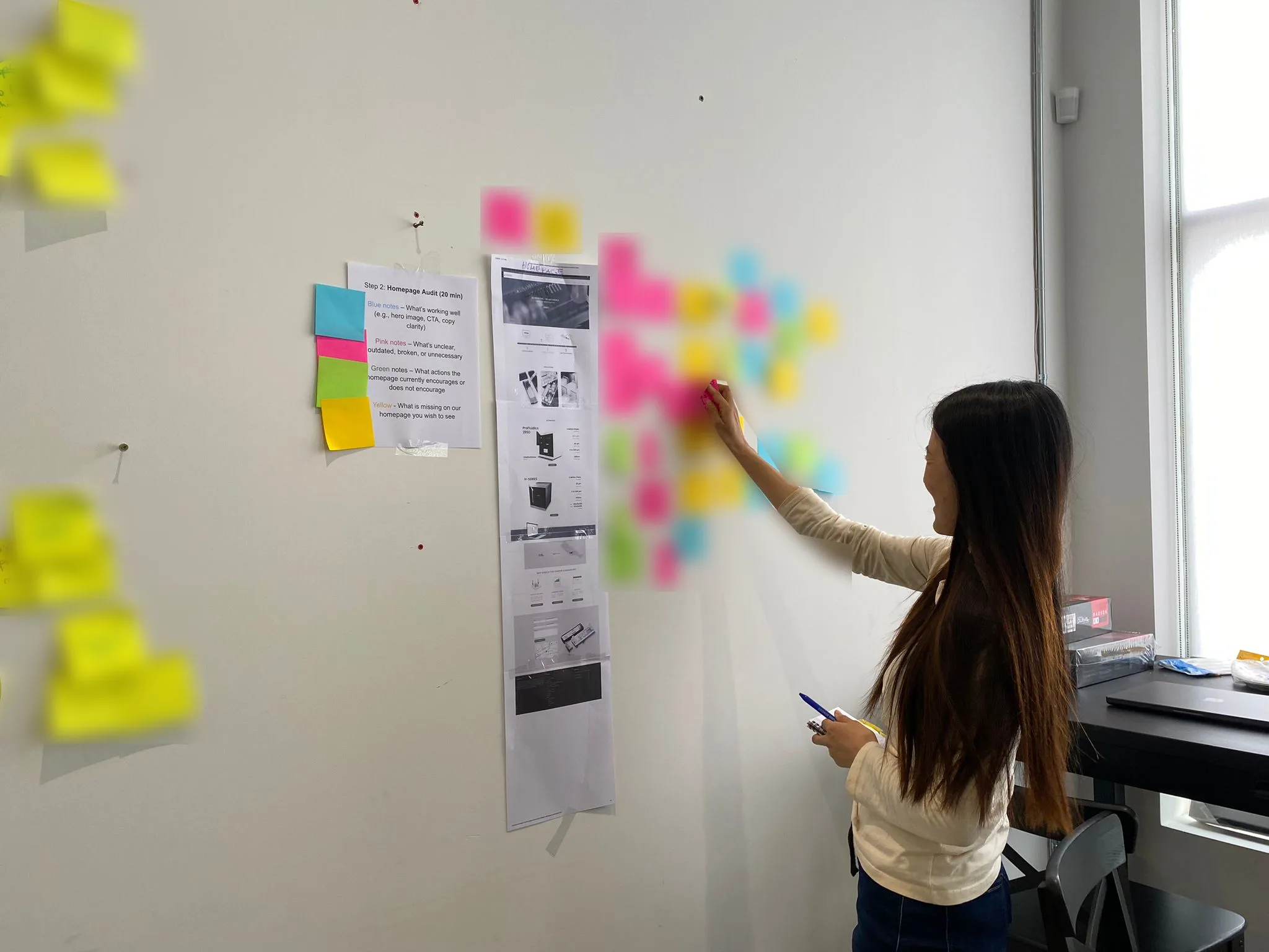 Reviewing the old homepage with colour coded sticky notes during the team heatmap review