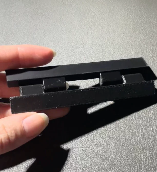 A printed test hinge held between fingers