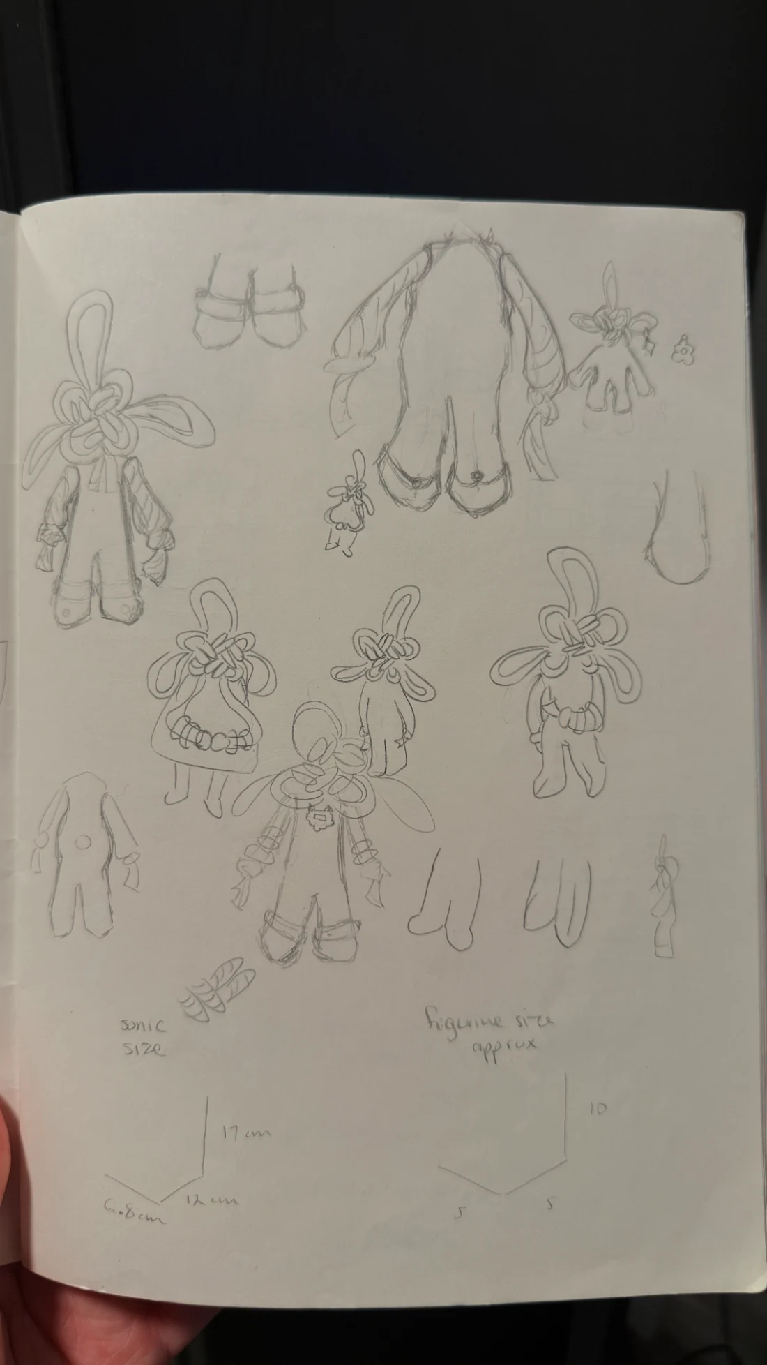 Sketchbook page of knot-headed character explorations with size notes
