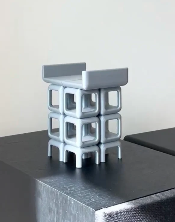 The small grey prototype of the shelf, standing on a speaker